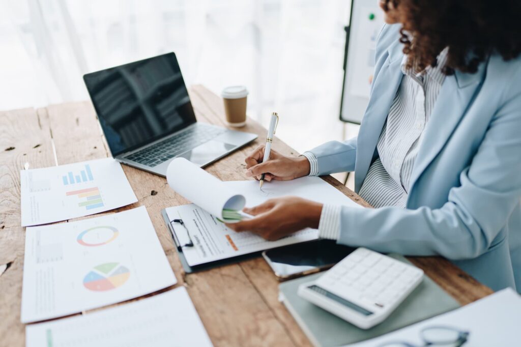 businesswoman using laptop computer and paperworks with planning working on financial document