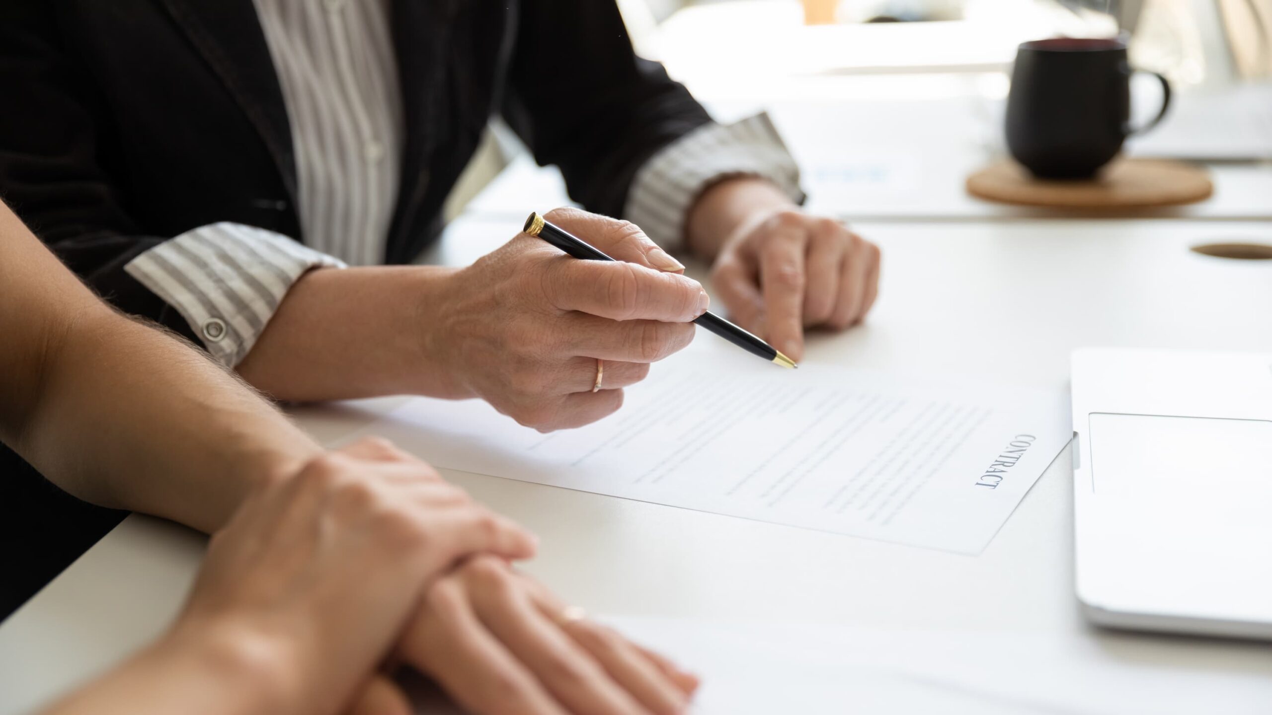 Hands of elderly female client, mature business leader, senior businesswoman reading and signing contract with assist of lawyer, solicitor.