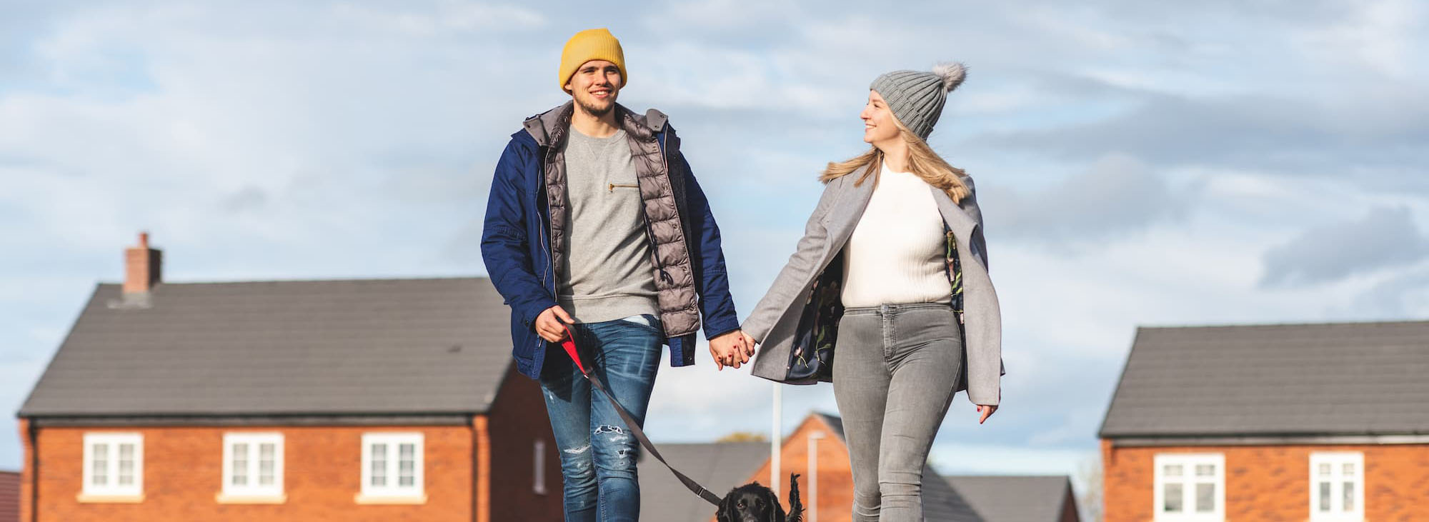 A couple walking on a crisp day with their dog