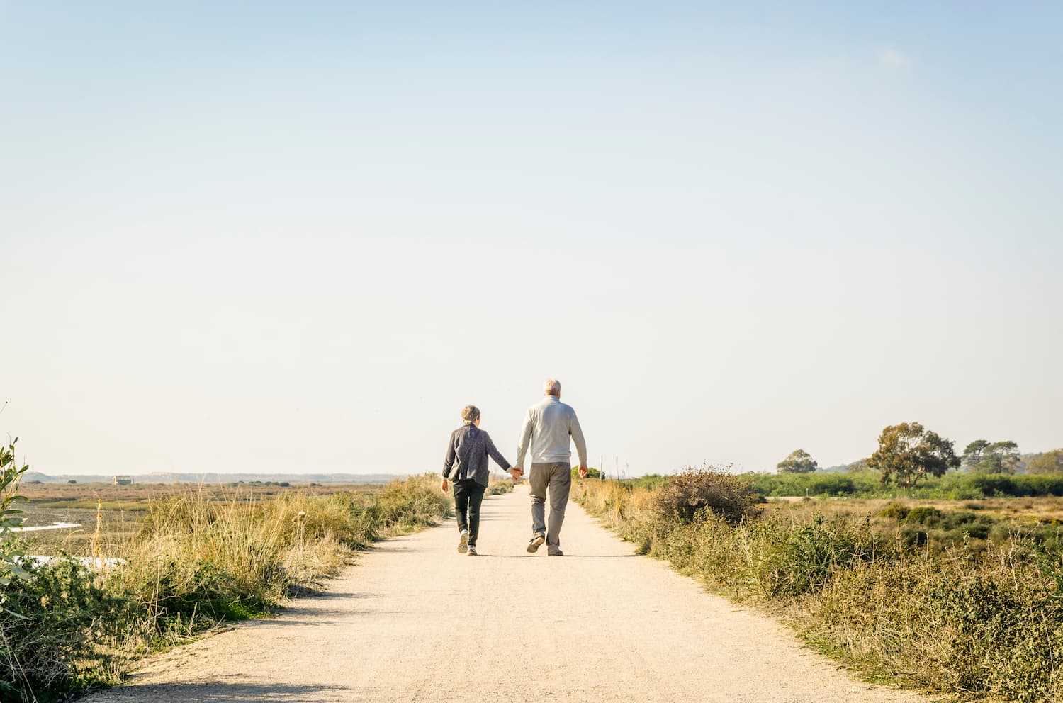 Elderly couple in love walking on a dust road